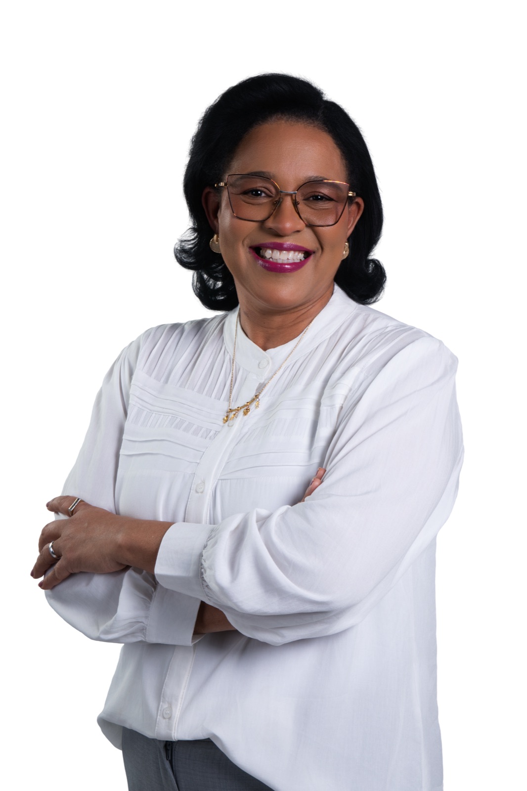 Vera Pinheiro de braços cruzados, sorrindo